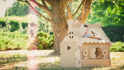 Image showing boy playing in cardboard house