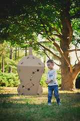 Image showing child playing in a cardboard spaceship. Eco concept