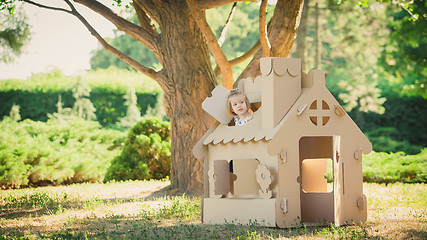 Image showing girl playing in cardboard house at city park