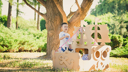 Image showing Boy and girl playing in a cardboard boat