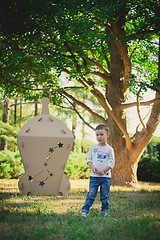 Image showing child playing in a cardboard spaceship. Eco concept