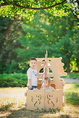 Image showing Boy and girl playing in a cardboard boat