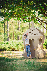 Image showing child playing in a cardboard spaceship. Eco concept