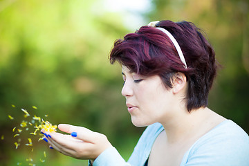 Image showing Woman Blowing Flower Petals