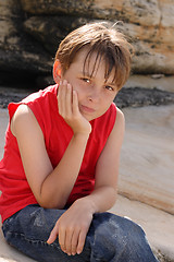 Image showing Child sitting on rocks