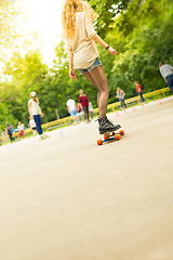 Image showing Teenage girl urban long board riding.