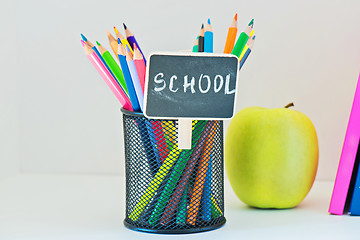 Image showing Pencils in holder, yellow appleand book