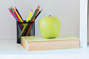 Image showing A yellow apple sitting on top of book