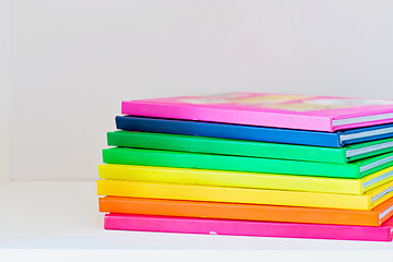 Image showing Multi colored books in stack on the light-coloured bookshelf