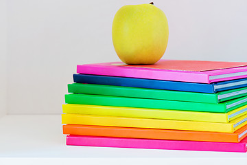 Image showing A yellow apple sitting on top of a stack of school books