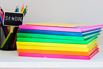 Image showing Multi colored books in stack on the light-coloured bookshelf