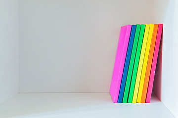 Image showing Multi colored books on the light-coloured bookshelf