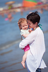 Image showing mother walking on beach and push baby carriage