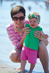 Image showing mom and baby on beach  have fun