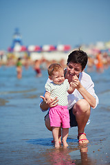 Image showing mom and baby on beach  have fun