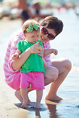 Image showing mom and baby on beach  have fun