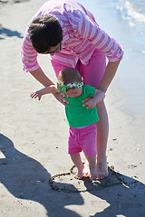 Image showing mom and baby on beach  have fun