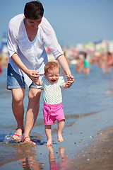 Image showing mom and baby on beach  have fun