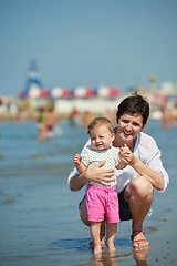 Image showing mom and baby on beach  have fun