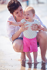 Image showing mom and baby on beach  have fun