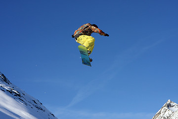 Image showing Snowboarder jumping high in the air