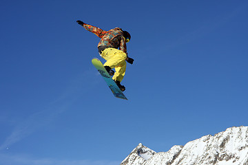 Image showing Snowboarder jumping high in the air