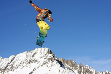 Image showing Snowboarder jumping high in the air