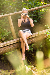 Image showing Woman in nature with retro camera.