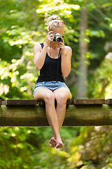 Image showing Woman in nature with retro camera.