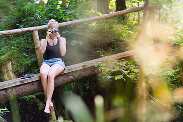 Image showing Woman in nature with retro camera.