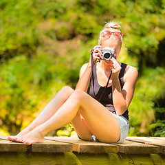 Image showing Woman in nature with retro camera.