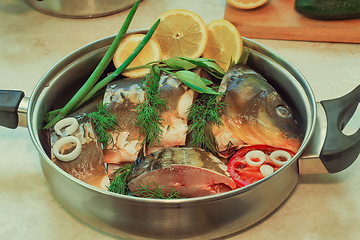 Image showing Fish and components for her preparation in a large skillet.