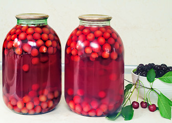 Image showing Home canning: large glass cylinders with cherry compote.