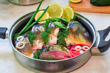 Image showing Fish and components for her preparation in a large skillet.