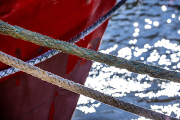 Image showing Mooring line of a trawler in backlight with water reflections