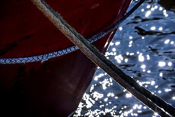 Image showing Mooring line of a trawler in backlight with water reflections