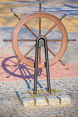 Image showing Old wheel of a sail boat in a harbor