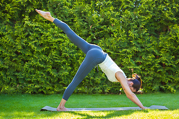 Image showing adult woman doing yoga in sunny morning park