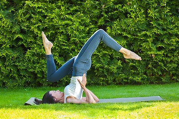 Image showing woman doing yoga on a green grass at summer day