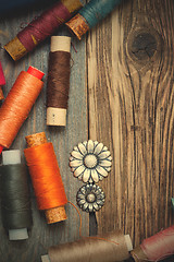 Image showing vintage buttons and old reels of varicolored thread on the text