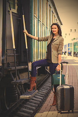 Image showing adult woman with a suitcase near the railway wagon