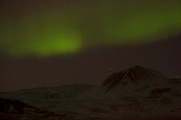 Image showing Northern lights with snowy mountains in the foreground