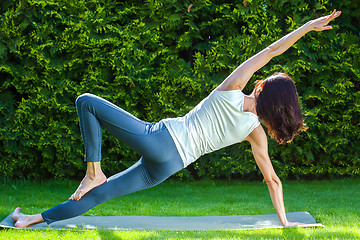 Image showing adult woman doing yoga on green grass