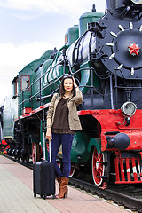 Image showing woman traveler with luggage near retro puffer