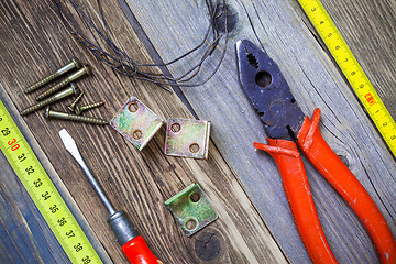 Image showing Vintage pliers, screwdriver, screws, wire, angles and roulette