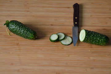 Image showing Cucumbers with a knife