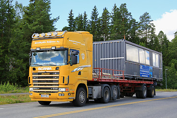 Image showing Yellow Scania 164G Truck Hauls Portable Cabin