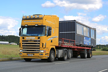 Image showing Yellow Scania 164G Truck Hauls Portable Cabin