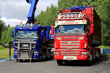 Image showing Red and Blue Scania Trucks on Display