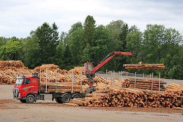 Image showing Volvo FH Truck Unloads Logs at Lumber Yard